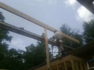 Carpenter setting a ridge beam over a new addition frame — Ice Dam Removal by Roofing Brothers in Brookwood