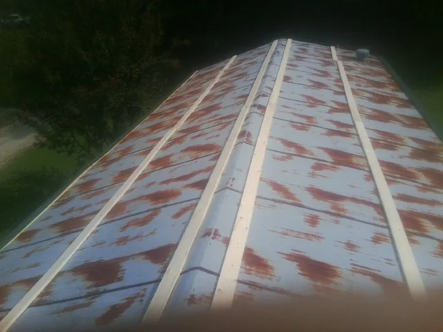 Rusted metal roof panels with new wood purlins before replacement — Storm Damage Roof Repair in Brookwood by Roofing Brothers