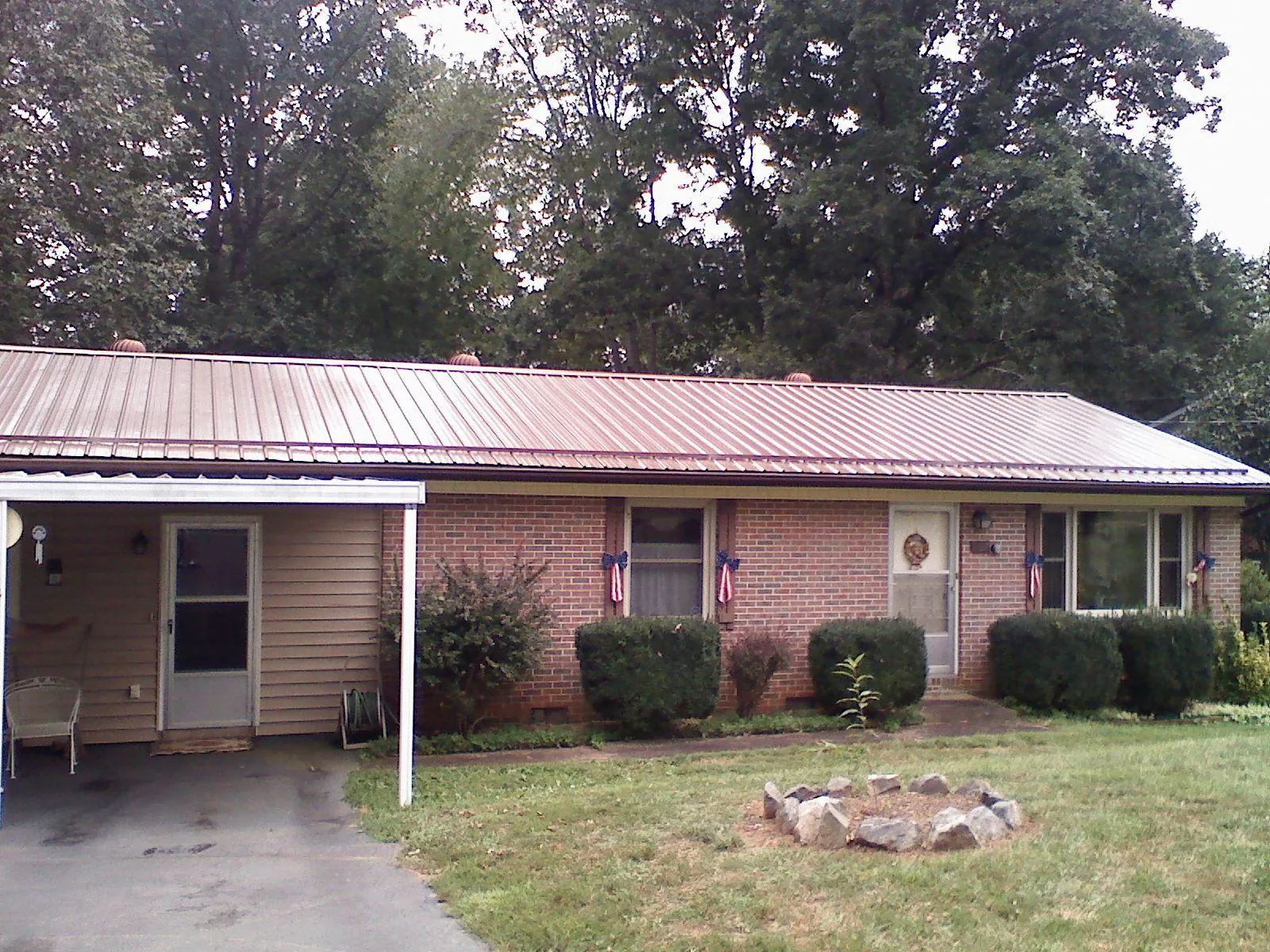 Bronze metal roof and carport on a brick ranch home — Roof Repair work by our crew in Brookwood