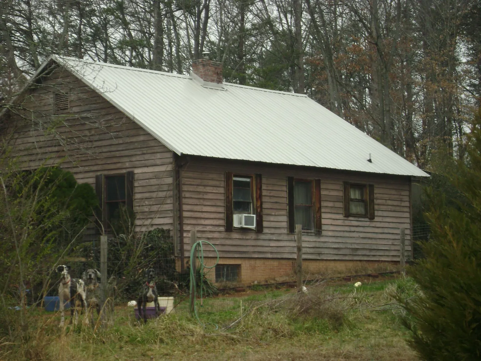 White metal roof on an old wood sided farmhouse, from a Metal Roof Installation job in Brookwood
